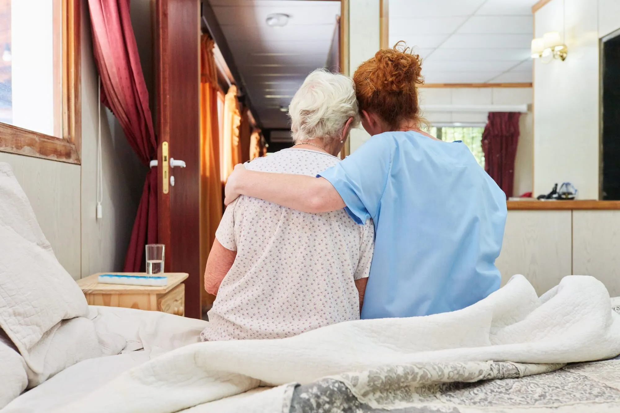 Hospice caregiver comforting a senior at home